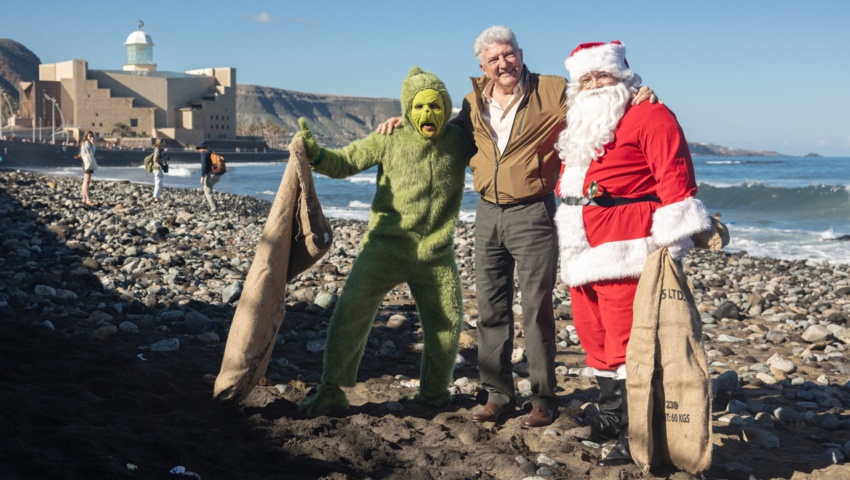 El Grinch y Papa Noel reivindican en la playa de Las Canteras una Navidad más verde y un océano más limpio